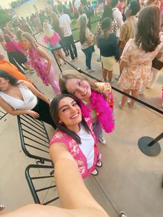 two women taking a selfie in front of a crowd