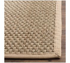 a beige rug on top of a wooden floor with a white border around the edges