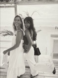 two women standing next to each other on a porch