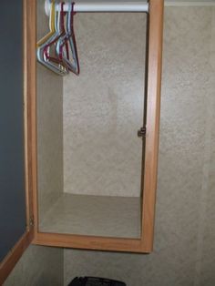 a bathroom with a mirror, towel rack and toilet paper dispenser in it