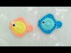 two small crocheted fish sitting next to each other