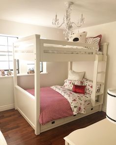 a white bunk bed with red and white bedspread