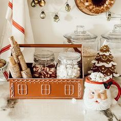 a kitchen counter topped with christmas decorations and jars filled with candies, marshmallows