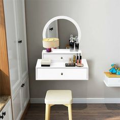 a white vanity with a mirror and stool in a room next to a wall mounted cabinet