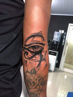 a man's arm with an eye and rose tattoo on the left side of his arm