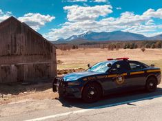 a police car parked in front of a barn