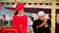 a man in uniform standing next to a woman wearing a red dress