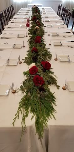 a long table is set up with place settings and flowers on the centerpieces