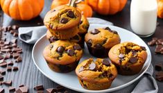 chocolate chip muffins on a plate with milk and pumpkins in the background