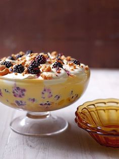 a bowl filled with food next to a glass bowl full of berries and other fruit