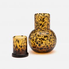 an animal print vase and candle holder on a white background