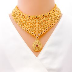 This necklace set, crafted in 22k yellow gold, weighs a substantial 90.0 grams and features a fascinating curved motif. It is richly adorned with uncut diamonds (Polki), totaling 24.78 carats, and rubies weighing 14.08 carats, creating a vibrant contrast. The set boasts a length of 16 inches, with a drop length of 1.25 inches, and is secured with a hook lock and adjustable links for a custom fit. Completing the ensemble are matching earrings, each 1.6 inches long, equipped with a screw back for Yellow Gold Kundan Necklace With Ruby For Celebration, Bollywood Style 22k Yellow Gold Kundan Necklace, Luxury Multicolor 22k Gold Kundan Necklace, Ornate 22k Yellow Gold Kundan Necklace, Luxury 22k Gold Bollywood Necklace, Polki Necklace Set, Bridal Jewelry Necklace, Precious Stones Rings, Diamond Pendant Sets