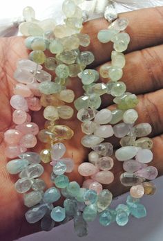 a hand holding several different colored stones