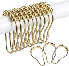 a bunch of gold balls hang on a white curtain rod with four pairs of hooks