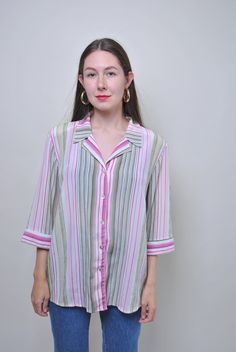 Add a pop of color to your wardrobe with this vintage striped multicolor blouse! This 90s secretary shirt is perfect for adding a retro touch to your outfit. Size: L Measurements (taken seam to seam while lying flat): Sleeve: 27cm / 10.62inch (armpit to end of sleeve) Width: 55cm / 21.65inch Length: 67cm / 26.37inch Made of polyester, this blouse is comfortable to wear and adds a fun and vibrant look to any ensemble. Please note that this item is vintage and may have some defects, which adds to Striped Collared Blouse For Spring, Trendy Striped Short Sleeve Blouse, Trendy Collared Shirt With Vertical Stripes, Spring Vertical Stripes Button-up Blouse, Spring Button-up Blouse With Vertical Stripes, Trendy Striped Collared Blouse, Spring Blouse With Vertical Stripes And Collar, Striped Collared Blouse, Summer Vertical Stripes Button-up Blouse