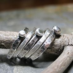 Set of FIVE stacking rings. Rustic stacking pebble rings accented by two textured fine silver bands. The 3 stackable sterling silver pebbles have been given an oxidized finish that is a great contrast to the two satin textured bright white fine silver accent rings. Meant to be slightly organic in shape, this rustic stack is a great casual, everyday look. They are also fun to play with, changing the position of the pebbles according to mood. when stacked on top of each other, they remind me of th Unique Hammered Stackable Rings For Promise, Stacked Sterling Silver Rings, Hammered Silver Stackable Promise Rings, Silver Hammered Stackable Promise Rings, Rustic Hand Forged Silver Rings, Hand Forged Sterling Silver Stackable Rings, Unique Hammered Silver Stackable Rings, Unique Hammered Stackable Rings For Anniversary, Unique Silver Stackable Rings With Hammered Detail