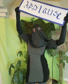 a woman dressed as a nun holding up a sign