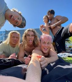 a group of people laying on top of a grass covered field next to each other