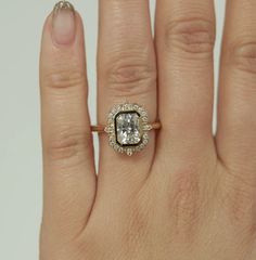 a woman's hand with a ring on it and a diamond in the middle