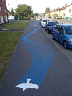 there are cars parked on the side of the road with blue lines painted on it