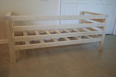 a wooden bed frame sitting on top of a floor next to a white closet door