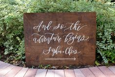 a wooden sign that says and so the adventure begins, with white writing on it