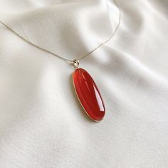 This stunning pendant is set in 14K Solid Yellow Gold with Natural Red Onyx with utmost precision. It is an unique gemstone pendant for nearly every occasion and is completely hassle-free jewelry. ITEM DETAILS * Gem: Red Onyx  * Gem Size: 15X40mm * Gem Shape: Oblong Oval cab * Gem Weight: 35.95 carats * Gold Purity: 14KT  * Gold Weight: 0.71 gram * Total Weight of the Pendant: 7.90 gram The Gold purity is guaranteed and it comes with authentic 14KT gold hallmark. Since my items are handmade, the Elegant Carnelian Necklace With Large Pendant, Red Oval Pendant Necklace With Polished Finish, Elegant Carnelian Jewelry With Large Pendant, Elegant Carnelian Gemstones For Gifts, Elegant Carnelian Gemstones As Gifts, Elegant Carnelian Gemstones As A Gift, Elegant Red Gemstones For Gift, Elegant Red Gemstones As A Gift, Elegant Carnelian Oval Pendant Jewelry