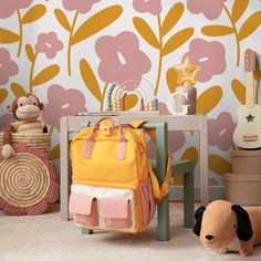 a child's room with pink and yellow flowers on the wall next to a toy dog