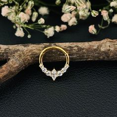 a gold nose ring with three small diamonds