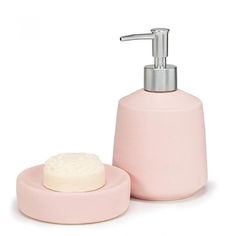 a pink soap dispenser next to a white soap dish on a white background