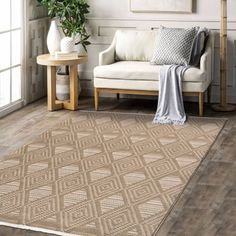 a living room with white walls and wooden floors, a beige rug on the floor