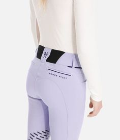 a woman in white shirt and purple pants with black trims on the bottom half of her leg