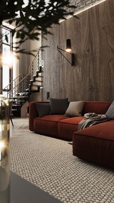 a living room filled with furniture next to a stair case and wooden paneled wall