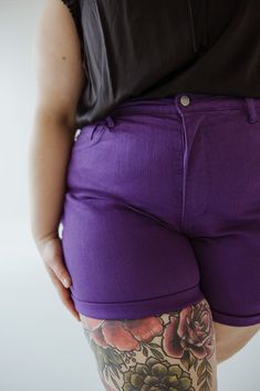 Don't let the name fool you, and these shorts are anything but plain! The TUMMY CONTROL ROLLED CUFF SHORTS IN PURPLE RAIN are high-waisted (12") for a flattering fit and feature a cuffed inseam of 5" (7" when uncuffed). Embrace the warmer weather with confidence and comfort. Fits true to Judy Blue sizing. If you have not worn Judy Blue jeans before, go one size down from your typical size. Cara is wearing a size 3x. Want more information about the model? Visit our Lovely Models page. Wash Handwa Purple Bottoms With Built-in Shorts And Short Inseam, Purple Bottoms With Built-in Shorts, Purple Fitted High-waisted Shorts, Fitted Purple Shorts Mid-thigh Length, Fitted Purple Shorts, Mid-thigh Length, Fitted Purple Mid-thigh Length Shorts, Purple Relaxed Fit Short Bottoms, Purple Relaxed Fit Shorts, Judy Blue Jeans