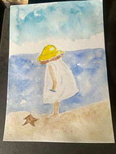 a watercolor painting of a girl on the beach with a yellow hat and starfish