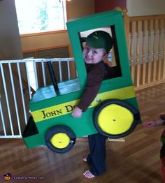 a young boy in a green tractor costume