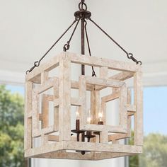 a chandelier hanging from the ceiling in a living room with windows and doors