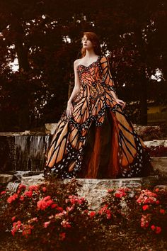 a woman in an orange and black butterfly dress