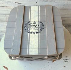 a wooden box with the word paris on it sitting on top of a white table