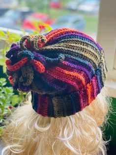 a close up of a knitted hat on top of a doll's head