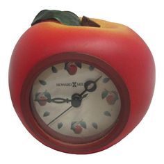 an apple shaped clock with a green leaf on top