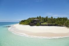 an island in the middle of the ocean with palm trees around it and a hut on top