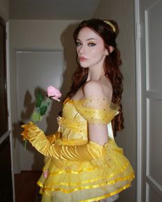 a woman in a yellow dress holding a rose