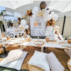 a table topped with lots of white and brown balloons