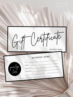 a gift certificate sitting on top of a white table cloth with palm fronds