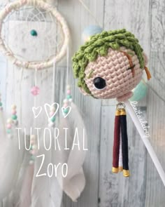 a crocheted doll hanging from a string next to a dream catcher with hearts