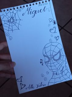 a hand holding up a paper with a spiderman on it and the words miguel written in black ink