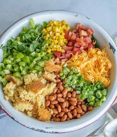 a white bowl filled with different types of food on top of a table next to utensils