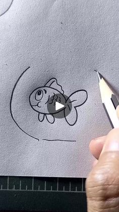 someone is drawing a fish with a pencil