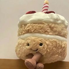 a teddy bear holding a large cake on top of it's head with a candle sticking out of it